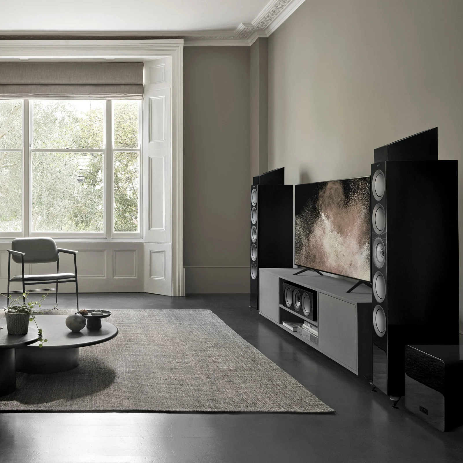 KEF R8 Meta placed atop a speaker for Dolby Atmos height effect