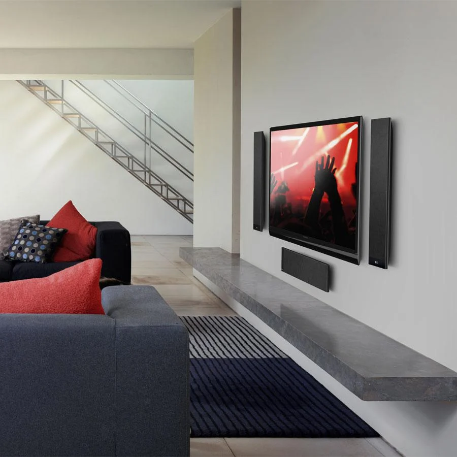 KEF T301 Black satellite speakers set up beside a flat-screen TV